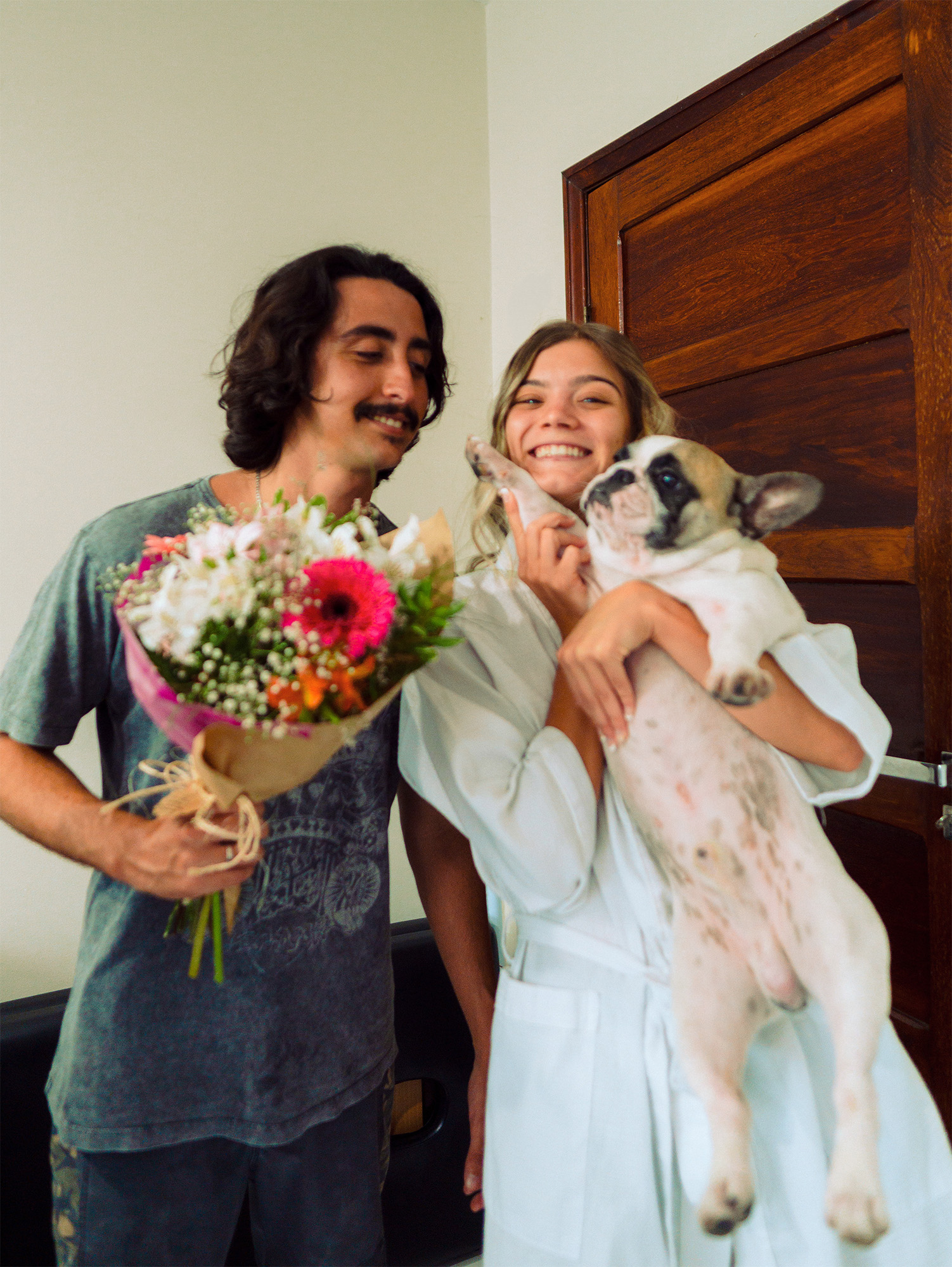Casal Jade e Bodevan com cachorro e buquê de flores